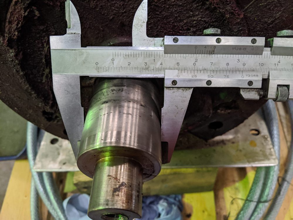 Vernier caliper measuring the outside diameter of a shaft sleeve on a pump